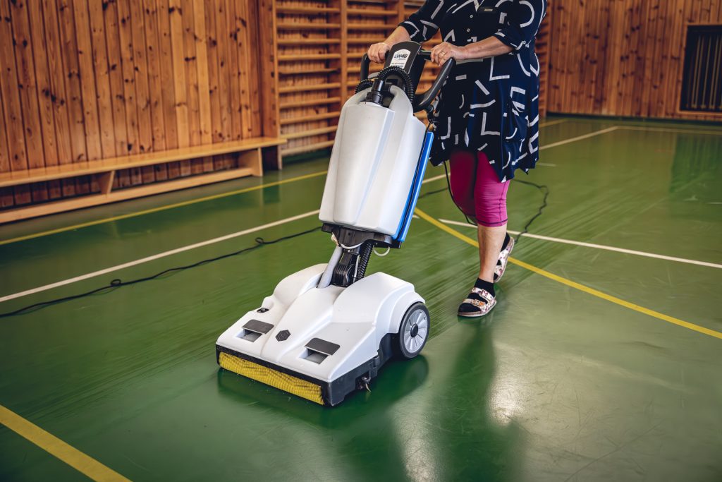 Zamestnankyňa si skúša umývací stroj Lindhaus v telocvični
