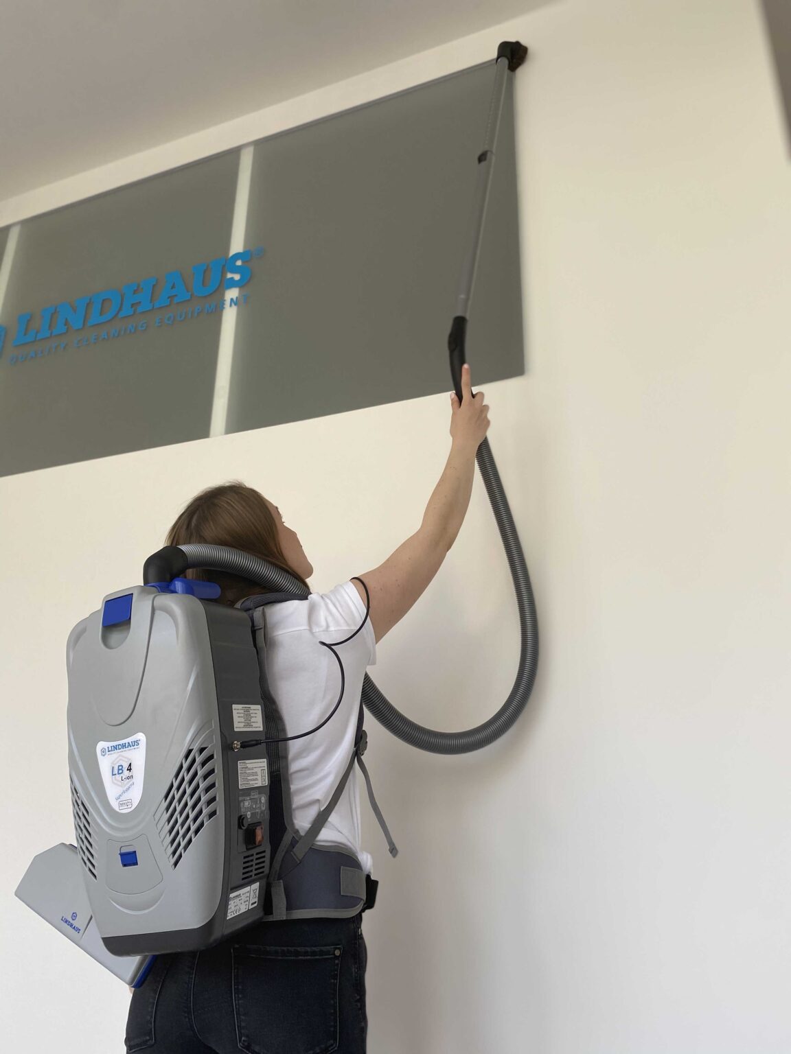 Chrbtový vysávač Lindhaus LB4 pri vysávaní vo výške